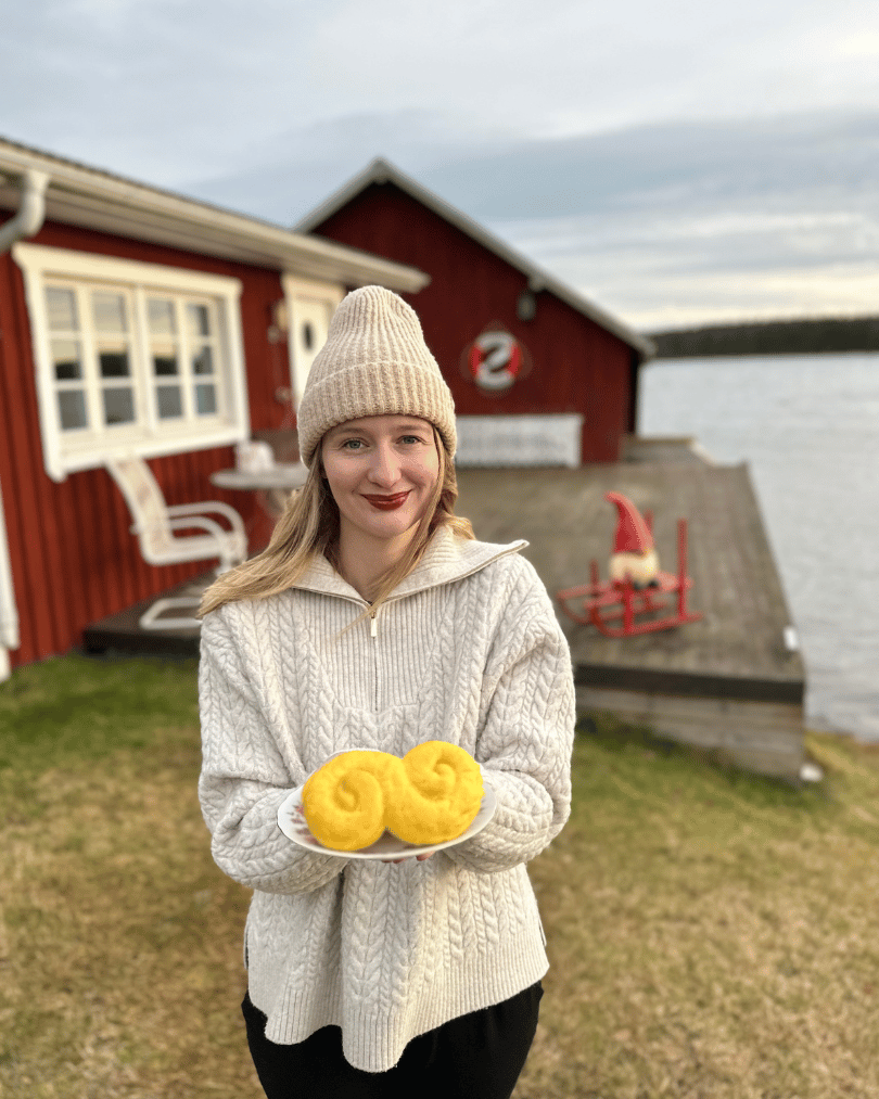 Kobieta w Szwecji trzymająca lussekatter – tradycyjne szwedzkie bułeczki szafranowe